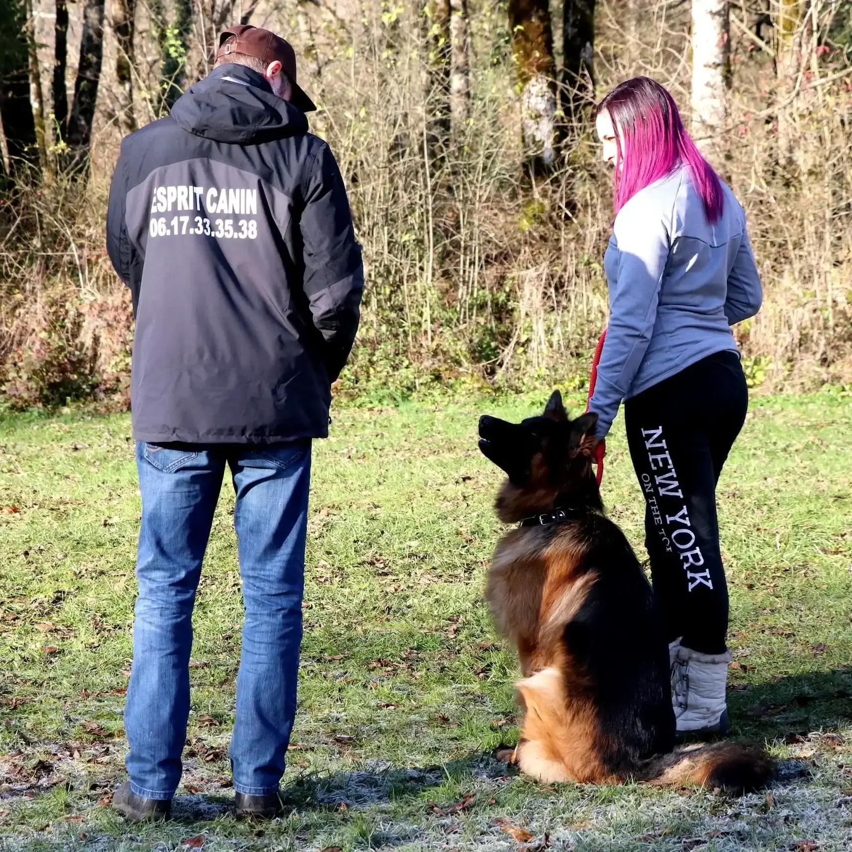 Educateur canin en séance d'éducation avec un berger allemand et sa maîtresse.